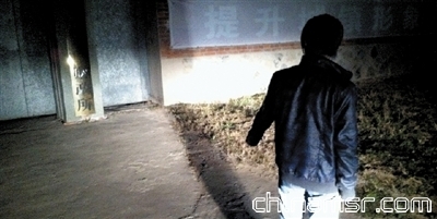 财政所门口，一名知情者在指认投放有毒食物的地点。本报记者 张剑 摄