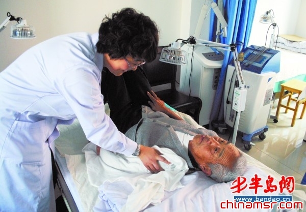 在胶南市泊里河东社区卫生服务站,今年74岁的崔明昌正接受中医理疗。